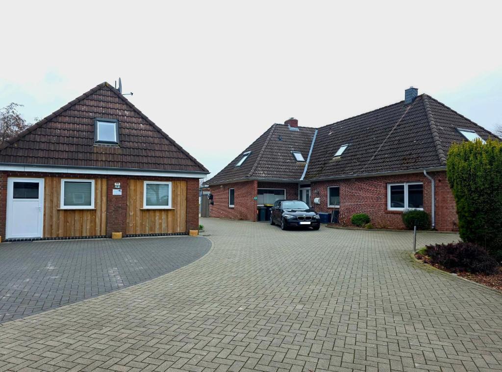 two brick houses with a car parked in the driveway at Haus Sonneneck in Oesterdeichstrich