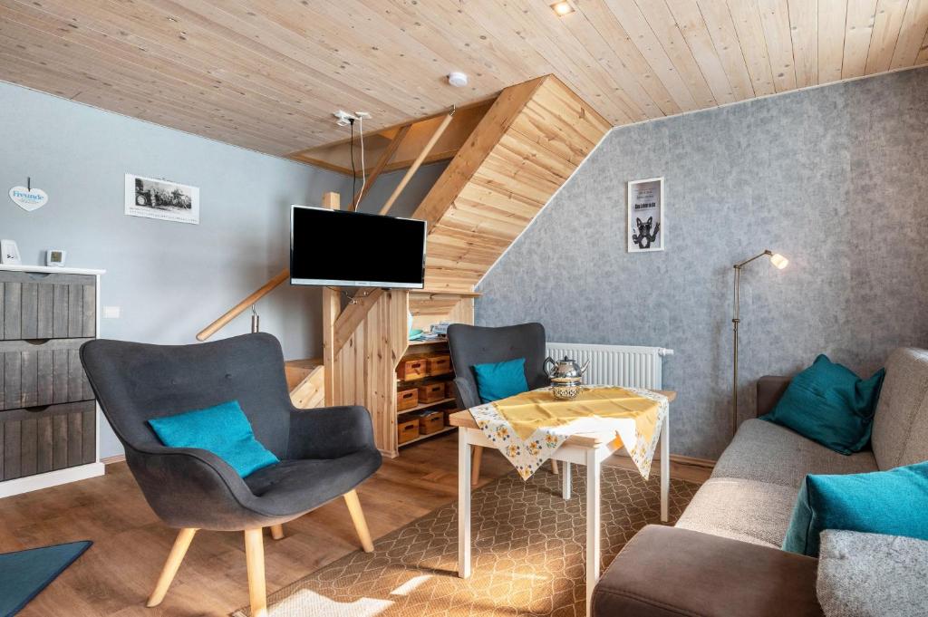 a living room with a table and chairs and a television at Ferien mit Hund Blomberg Ostfriesl in Blomberg
