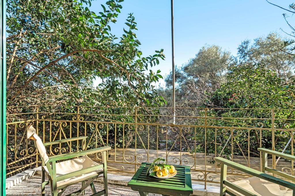 a patio with two benches and a bowl of fruit on a table at Old Boat double studio 4 in Nikiana
