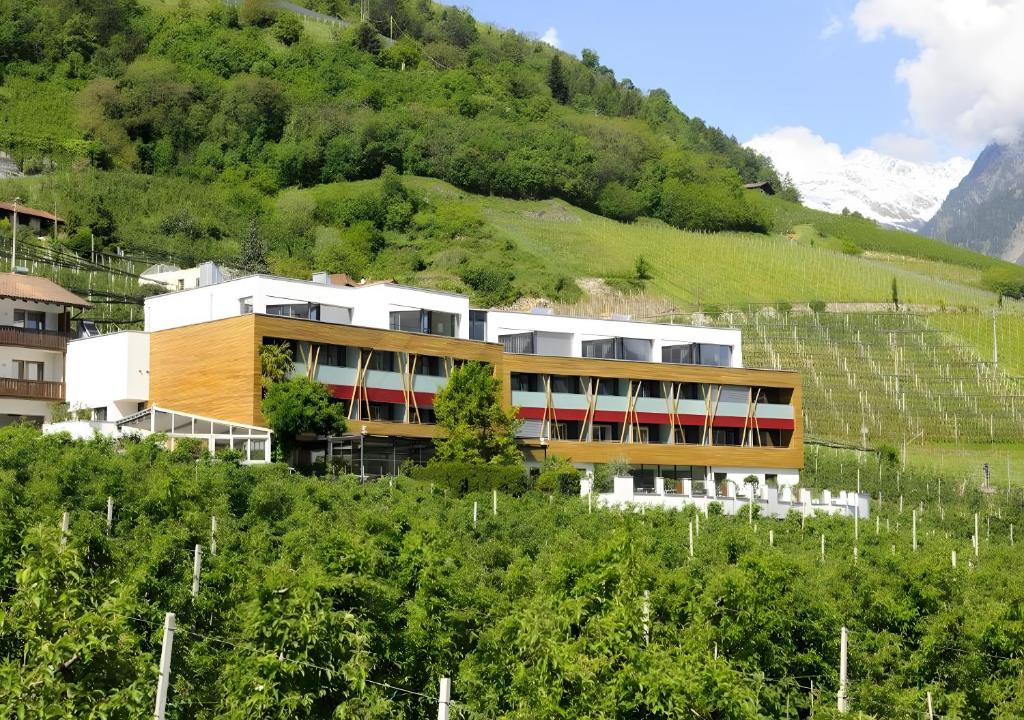 a building on the side of a hill at Bio Wellnesshotel Pazeider in Marlengo