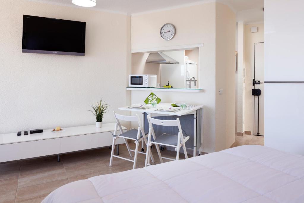 a white bedroom with a kitchen and a table and chairs at Seaviews A61 in Torrox Costa