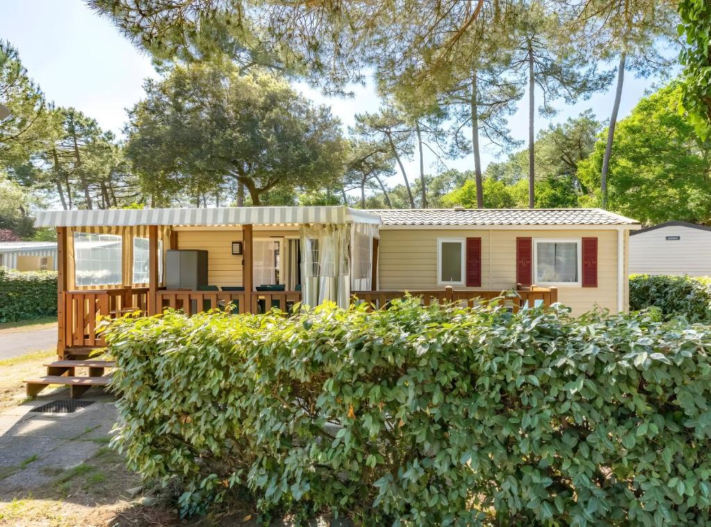 a tiny house with a porch and a deck at Mh324 La Tremblade in La Tremblade