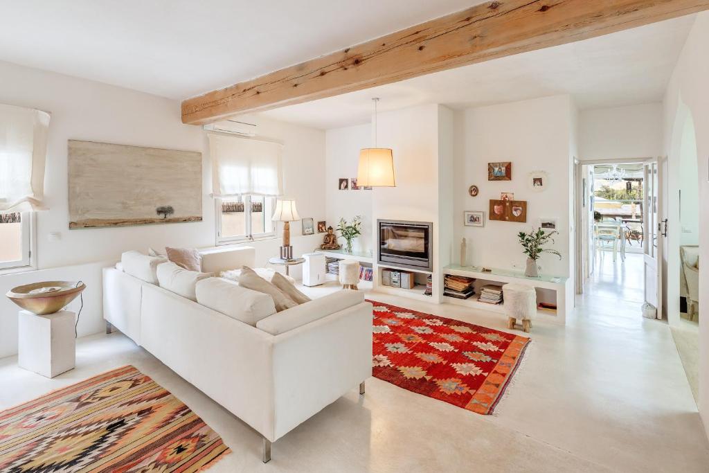 a living room with a white couch and a fireplace at Casa De La Mar 19 in Colonia de Sant Pere