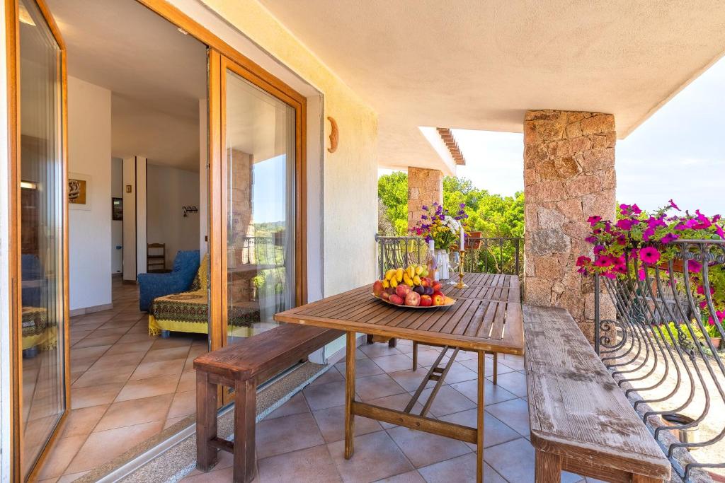 a table on a balcony with a bowl of fruit at Casa Valeria Costa Paradiso in Trinità d'Agultu e Vignola