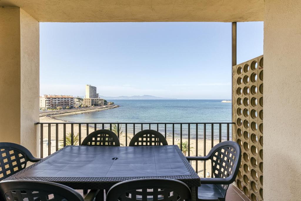 a table and chairs on a balcony with a view of the ocean at Riells Platja in L'Escala