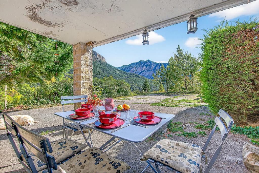 a table with red dishes on it on a patio at Gîte Le Montagn'art in Beauvezer