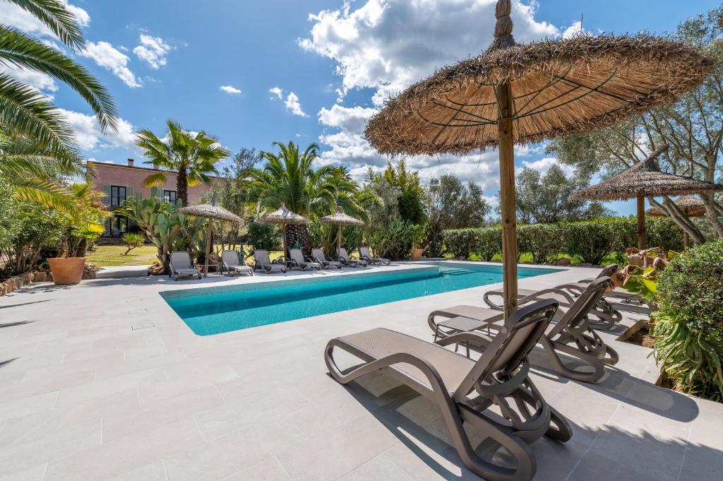 a swimming pool with chairs and an umbrella at Redonda 2 in Costitx