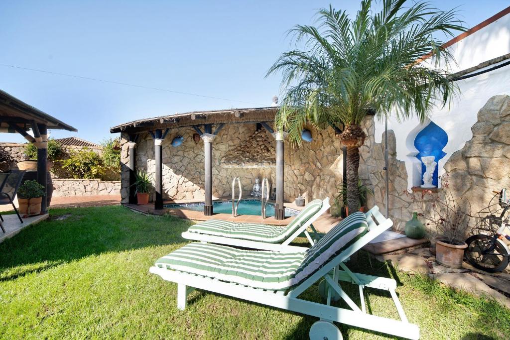 a pair of lounge chairs in a yard at Villa Indie in Chiclana de la Frontera