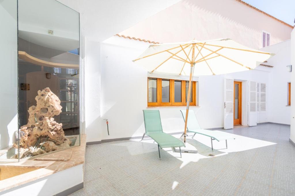 a white room with a chair and an umbrella at Can Maro in Santa Margalida