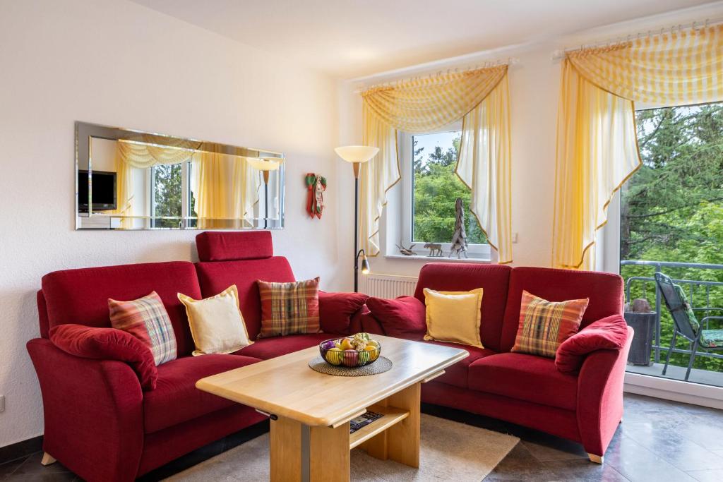 a living room with two red couches and a table at Ferienwohnung Tannenblick 6-1 in Oberhof