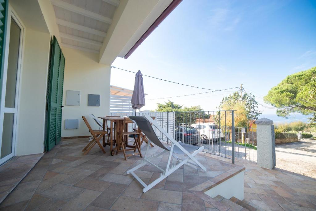a patio with a table and chairs and an umbrella at Il Timo in Marciana