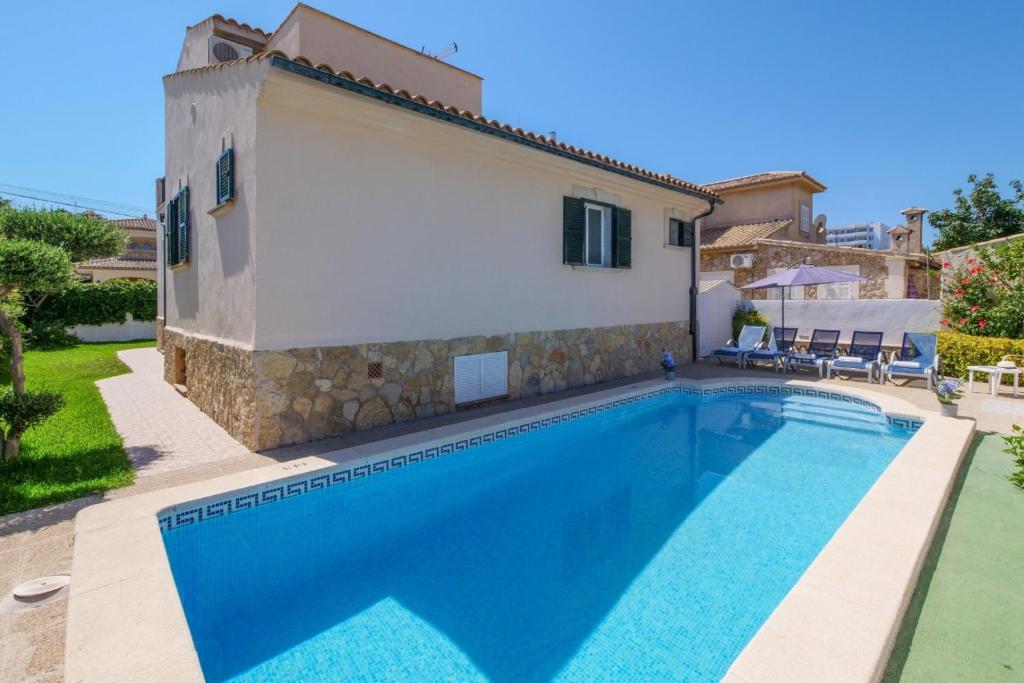 a villa with a swimming pool in front of a house at Villa Loli in Alcudia