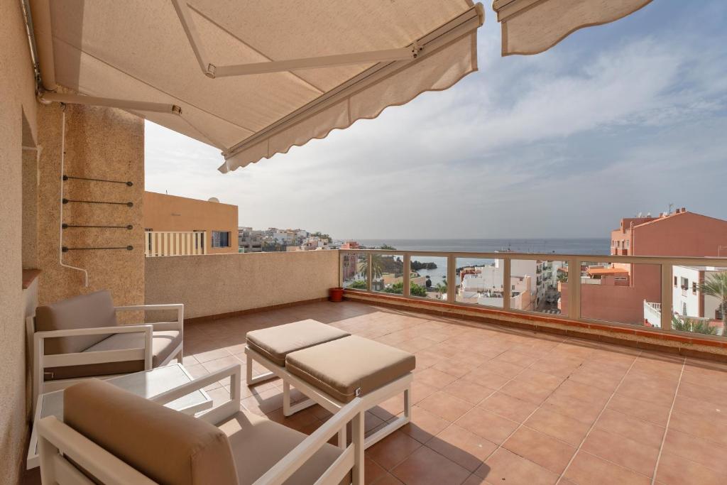 a balcony with a table and chairs and a view at Ático Bellavista B - Alcalá in Guía de Isora
