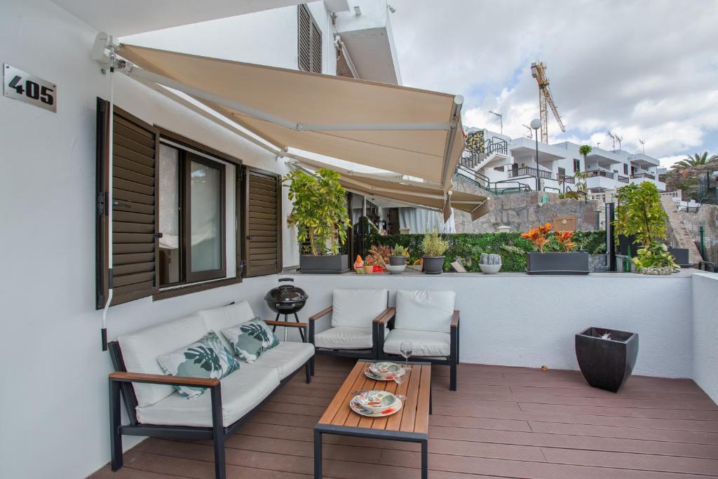 a balcony with a couch and chairs and a table at Sun and serenity pool wifi in Puerto Rico de Gran Canaria