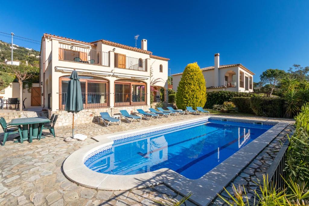 a villa with a swimming pool and a house at Villa Rosa in Calonge