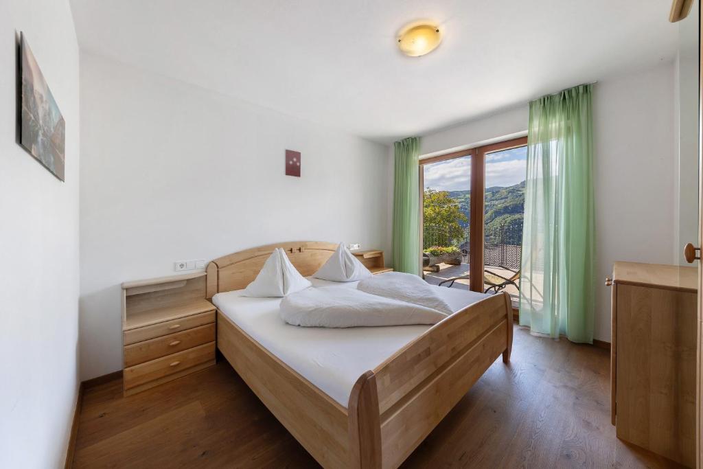 a bedroom with a bed and a large window at Obertrisaierhof Wohnung 2 in Fie allo Sciliar