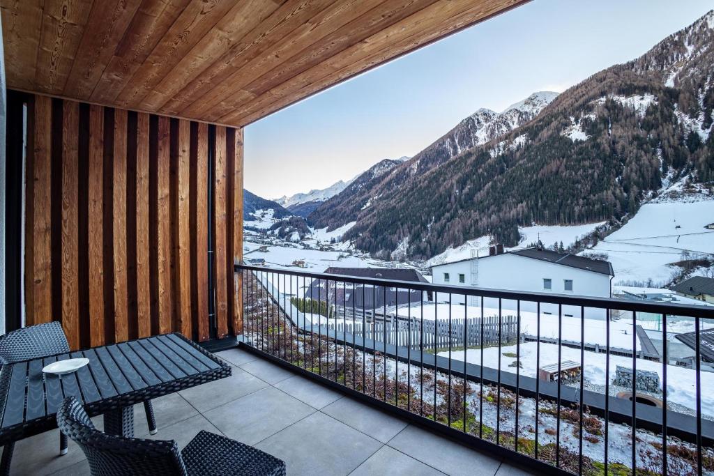 a balcony with a table and chairs and mountains at Stoana Apt 2-2 in San Giacomo