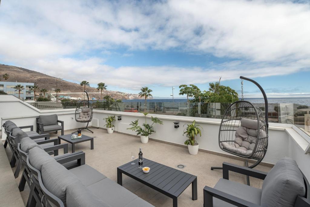 a patio with chairs and tables on a balcony at Villa Atlantico in Candelaria