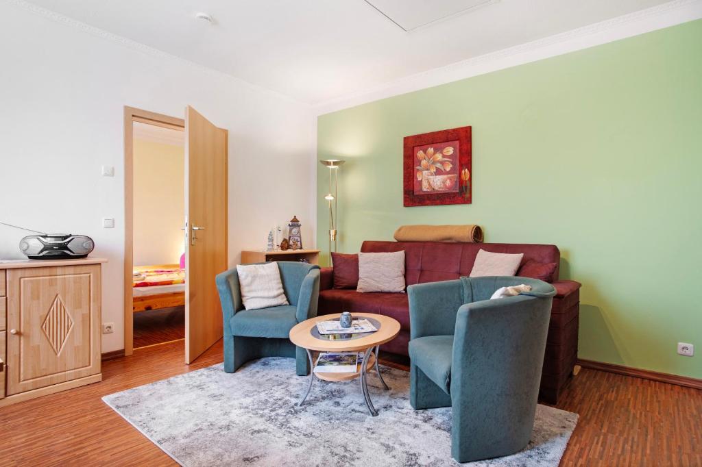 a living room with a couch and two chairs and a table at Ilse - Ferienwohnungen Zinnowitz in Zinnowitz