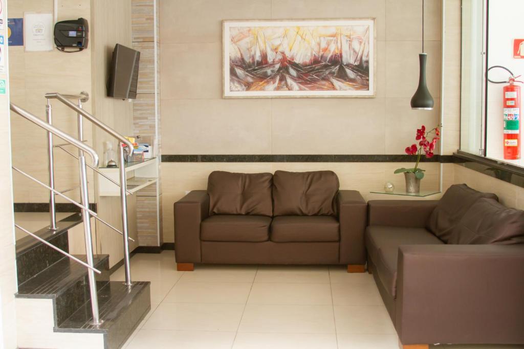 a living room with a couch and a painting on the wall at Pousada São Luiz in Aracaju