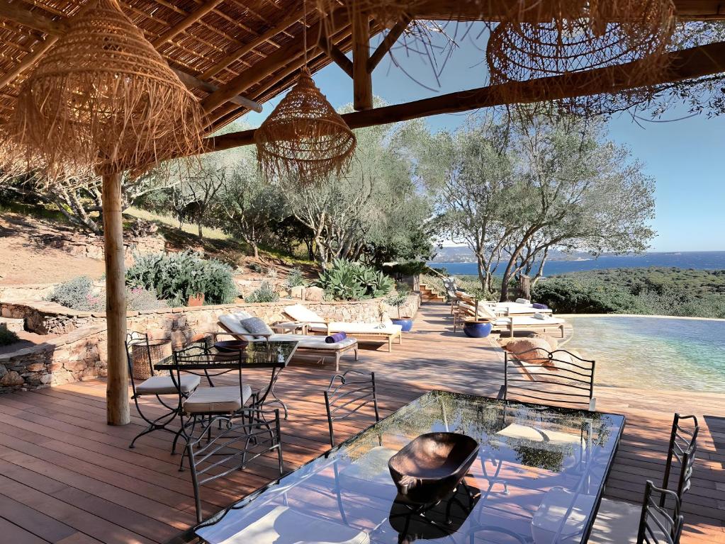 a patio with chairs and tables and a pool at Casa Penisula in Porto-Vecchio