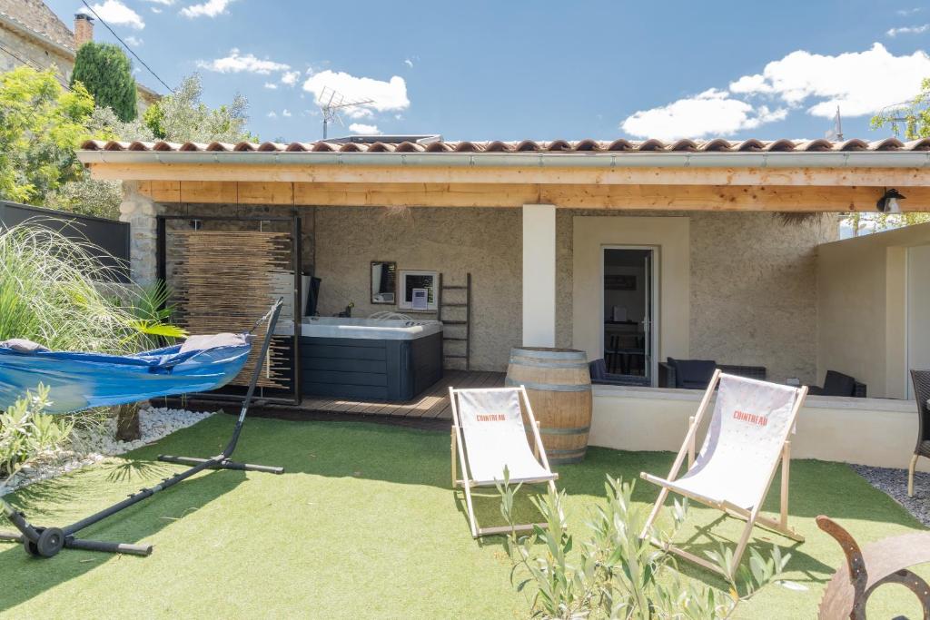 two chairs and a hammock in a yard at Villa chardonnay in Pradons