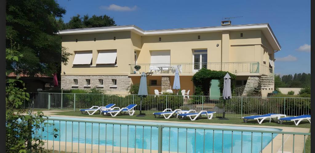 a villa with a swimming pool in front of a house at Gite La Lède in Bias