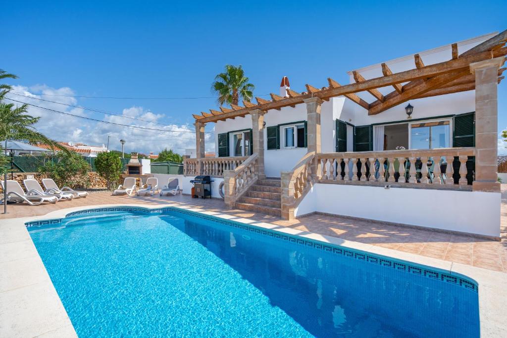 a villa with a swimming pool and a house at Villa Petre in Cala en Porter