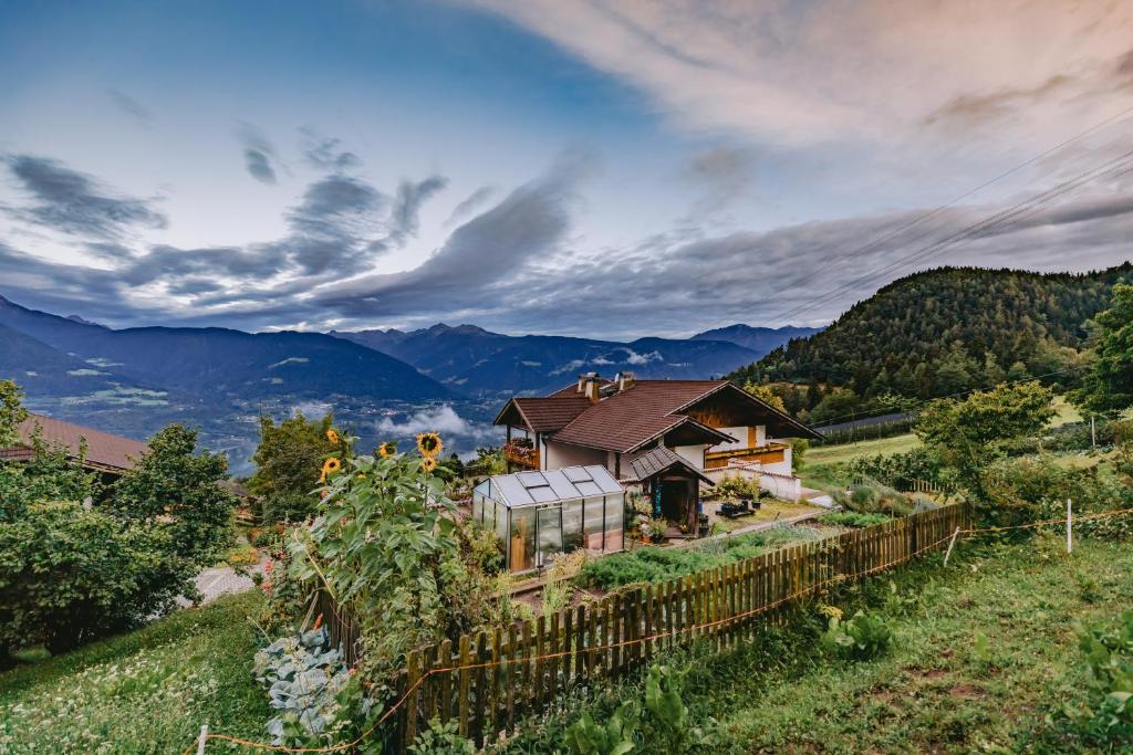 a house on a hill with mountains in the background at Eichernhof Apartment Apfelblüte in Verano