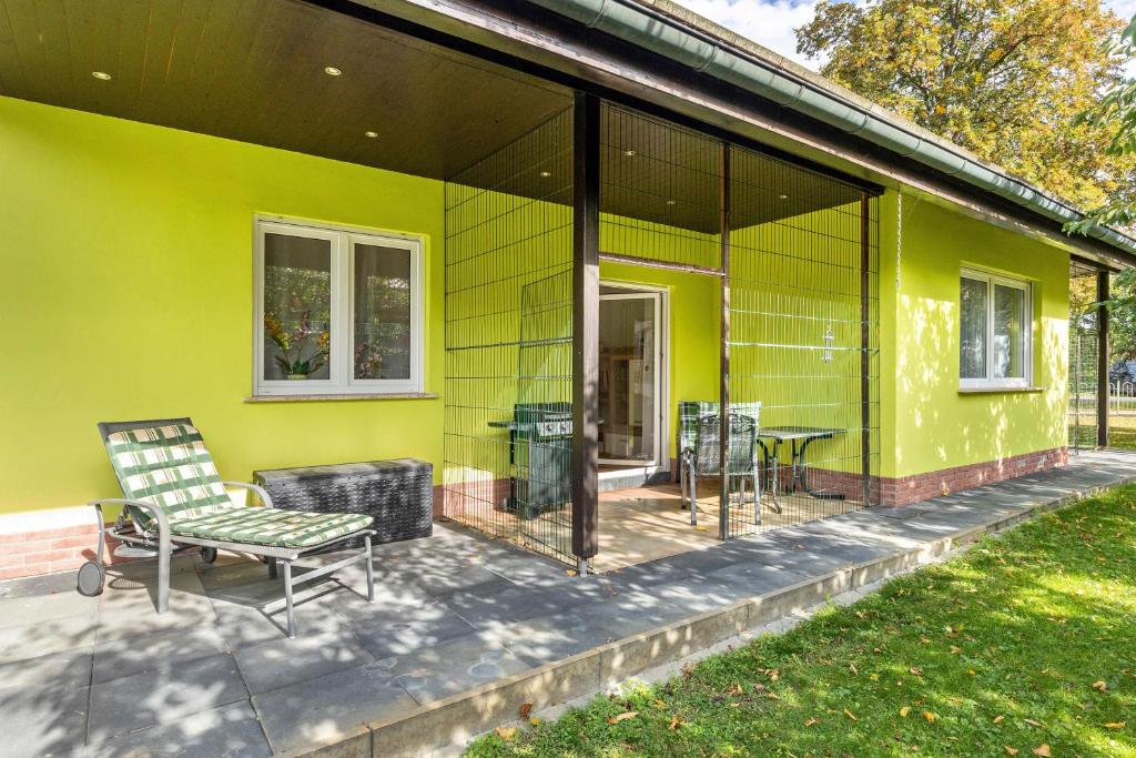 a green house with a bench and a table at 2 Zimmer Ferienwohnung 69 Qm in Mittenwalde