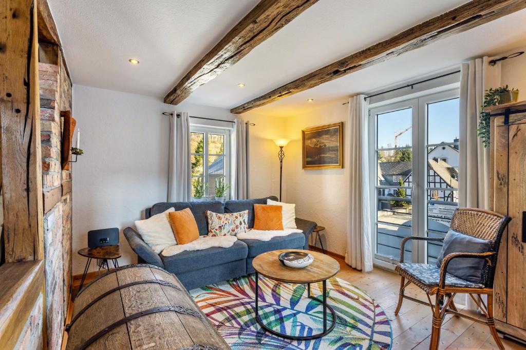 a living room with a blue couch and a table at Ferienhaus Glücksschmiede in Schmallenberg
