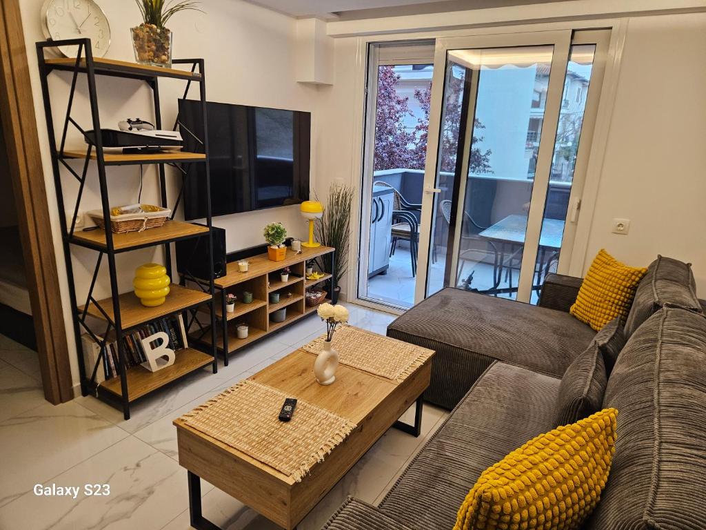 a living room with a couch and a table at Blue Wave in Paralia Katerinis