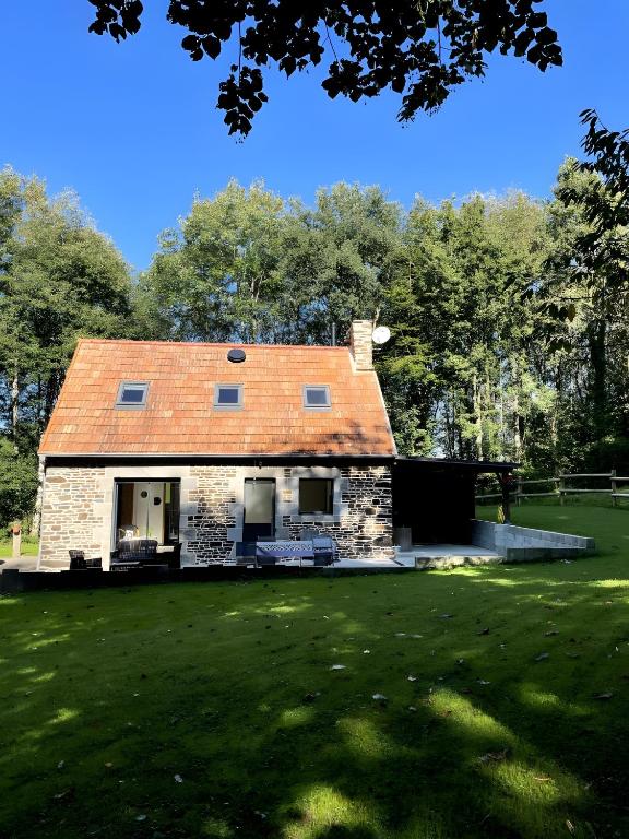 una vecchia casa con il tetto rosso su un campo di Gite Ranch a Tirepied