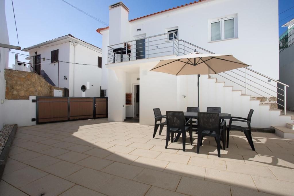a patio with a table and chairs and an umbrella at T3 São Martinho do Porto in São Martinho do Porto