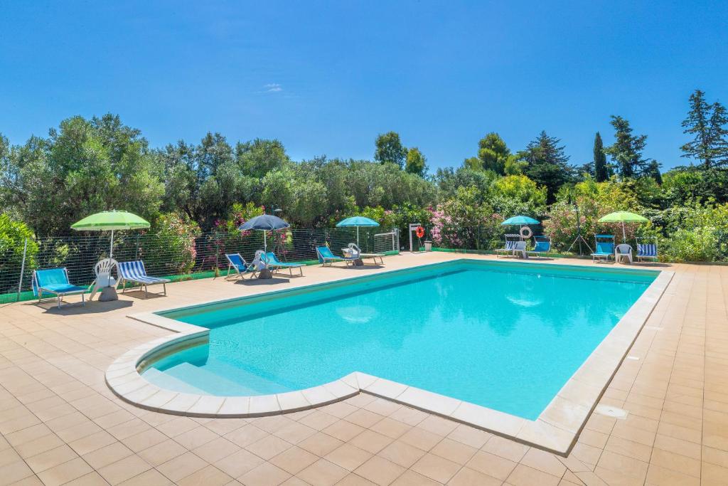 a large swimming pool with chairs and umbrellas at Il Nazareno - Civetta in Cecina