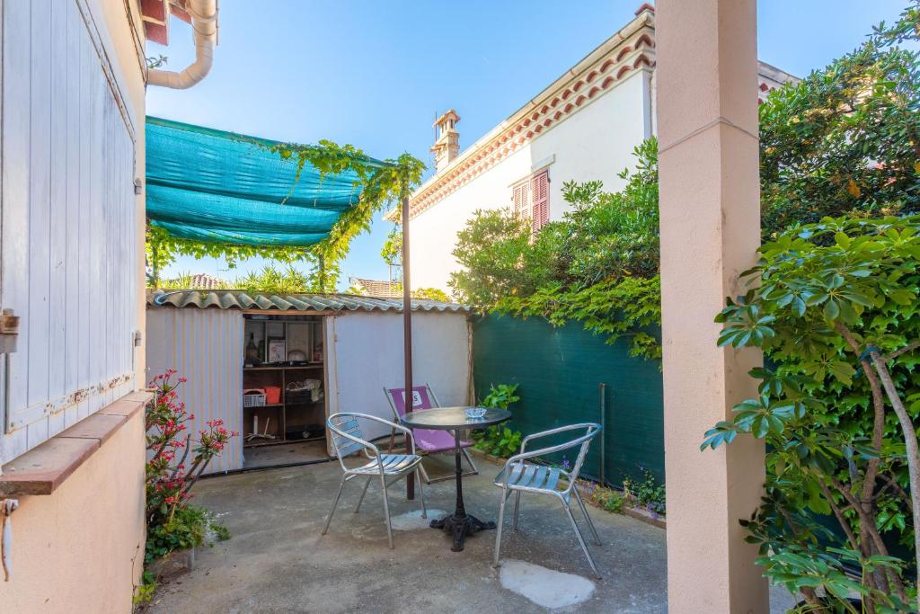 a patio with a table and chairs in a courtyard at Chez Lina - studio avec terrasse in Le Lavandou
