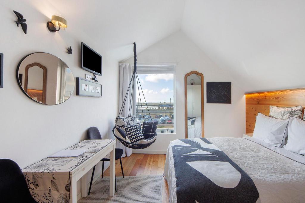 a bedroom with a bed and a hanging swing at Salina Ria Studio in Aveiro