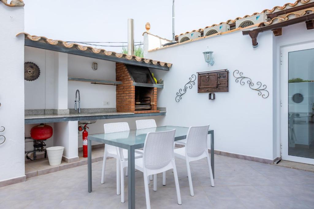 a patio with a blue table and white chairs at La Casita in Pollença