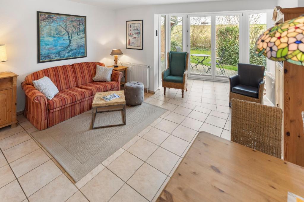 a living room with a couch and two chairs at Deichblick in Böhl