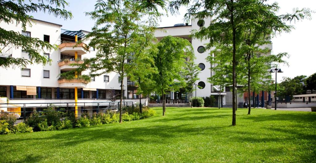 a park with trees in front of a building at La Cordata Accommodation - Zumbini 6 in Milan