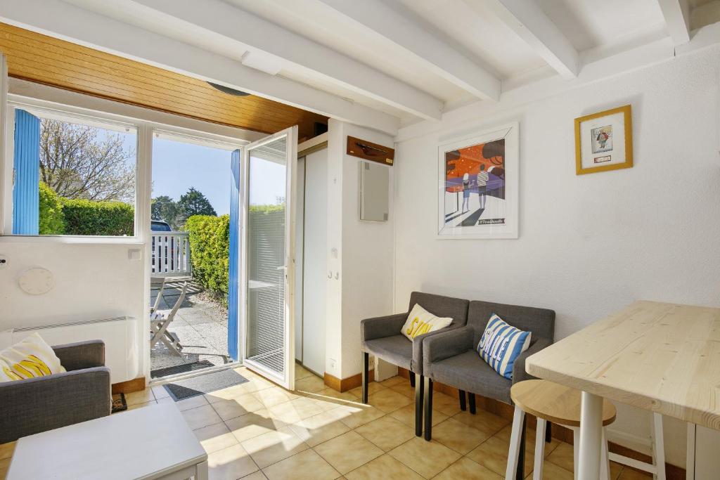 a living room with a table and chairs at Ty Dacoli - piscine et plage in Le Pouliguen