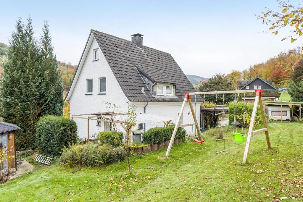 a house with a yard with two swings at Yalet Ferienhaus in Brilon