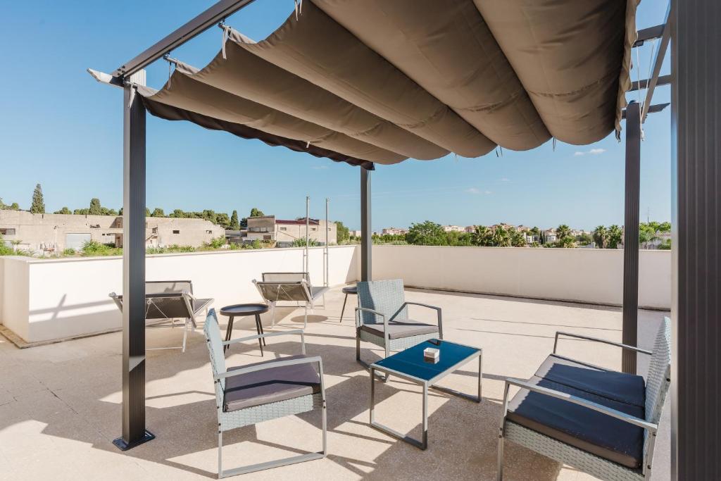 a patio with chairs and tables on a roof at Bed And Breakfast Champagneria in Castelvetrano Selinunte