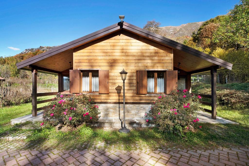 a small wooden house with flowers in front of it at Casa Bucaneve in Barzio