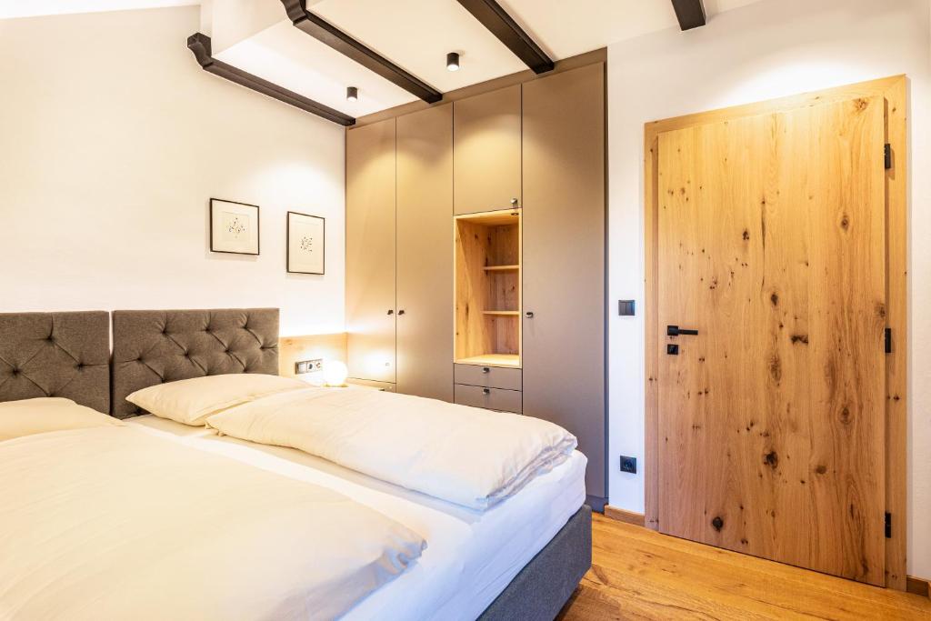 a bedroom with a large bed and a wooden door at Residence Skutial App Santner in Castelrotto