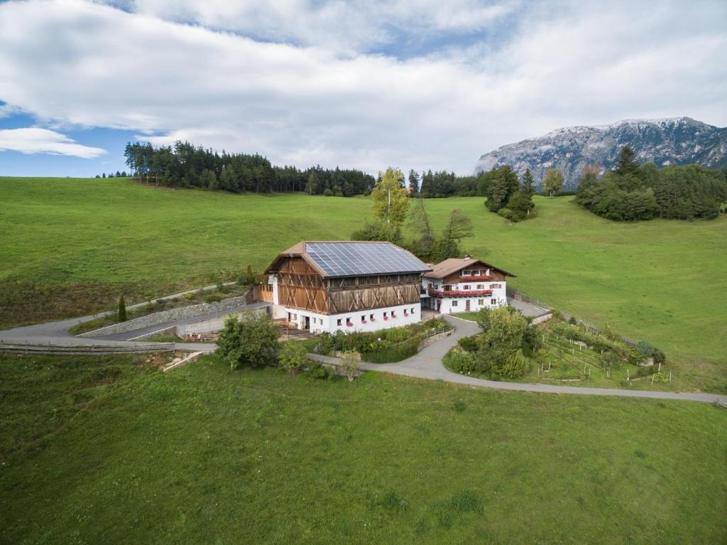 an aerial view of a house in a green field at Stampferhof in Völs am Schlern