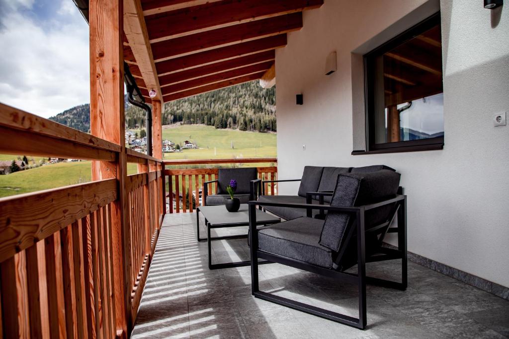 a balcony with two chairs and a view of a mountain at Kieserhof Apartment Berg in Terento