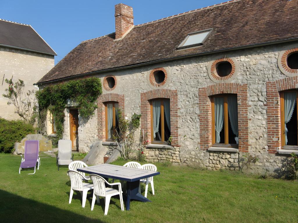 a table and chairs in front of a building at Haras de la fontaine Diva in Poligny