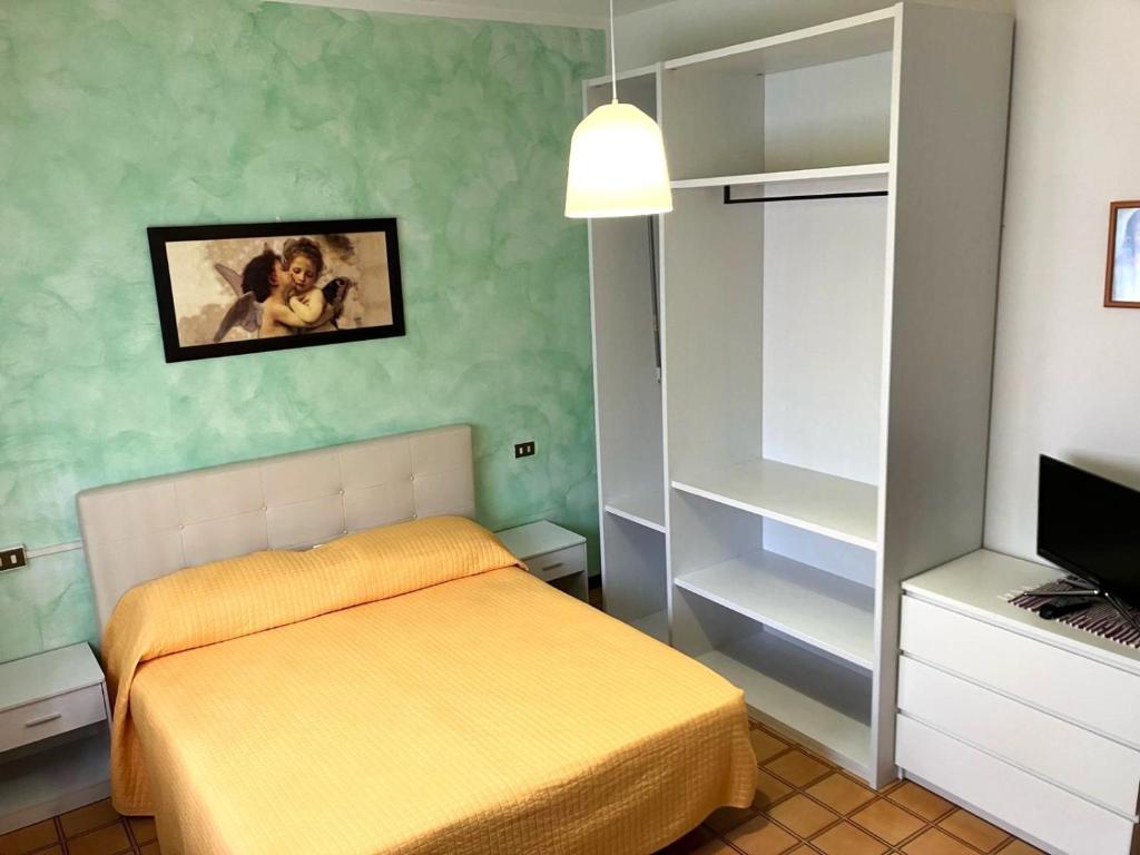 a small bedroom with a bed and a tv at Sole Apartment in Rimini