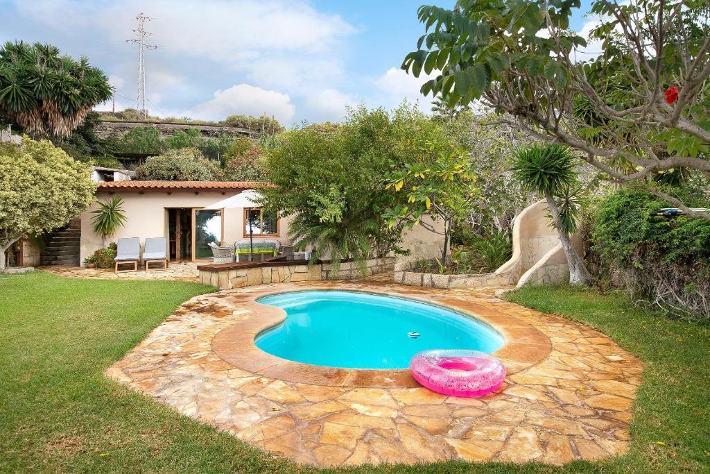 a pool with a frisbee in front of a house at Casa Anakena in Guía de Isora